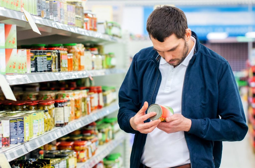 persona leyendo etiquetado nutricional de alimentos en el supermercado